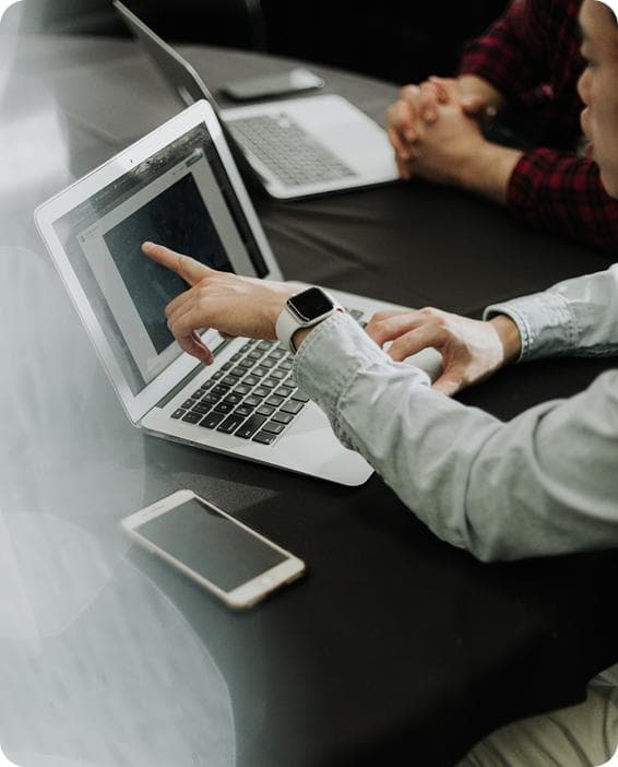 Professionals collaborating around a laptop during a brand strategy session.